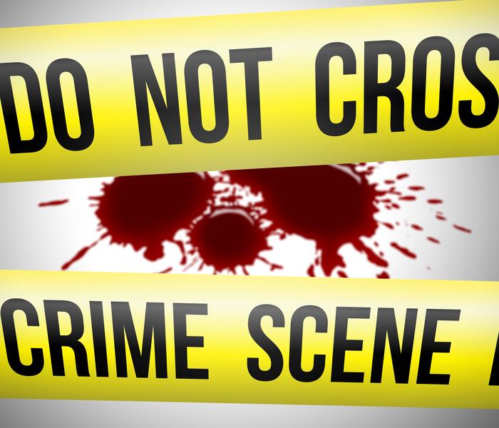 yellow do not cross crime scene tape with blood splatter in background