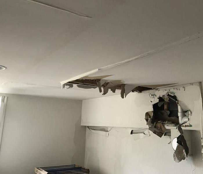 water damage causing the ceiling and walls of the floor underneath to peel