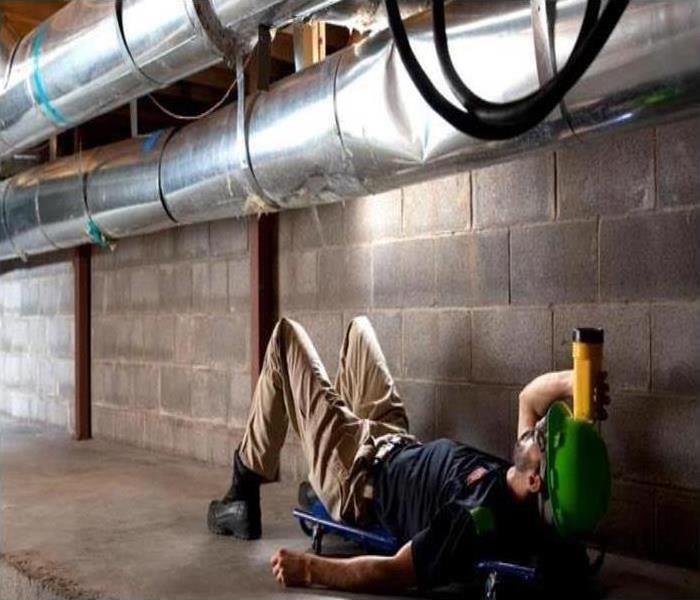 Person laying on back inspecting HVAC