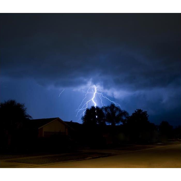 “lighting striking hillside during storm at night” 